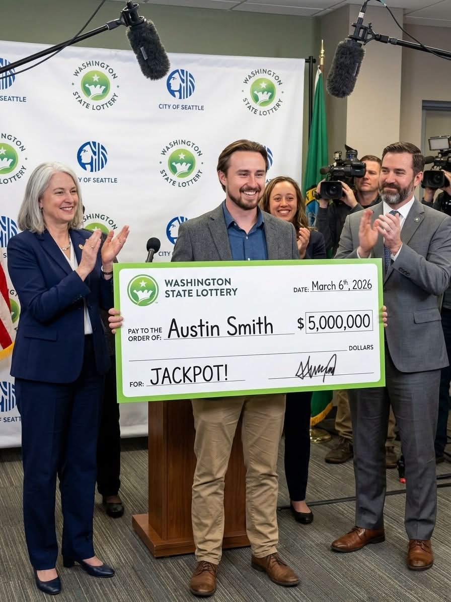 Austin Smith holds an oversized ceremonial check after winning the Washington State Lottery jackpot